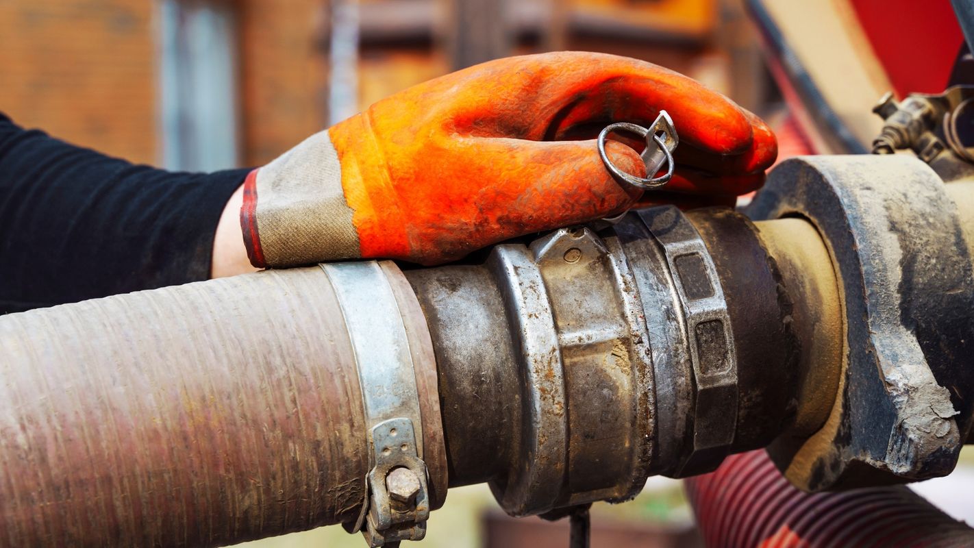 A professional pumping a septic tank in a rural setting.