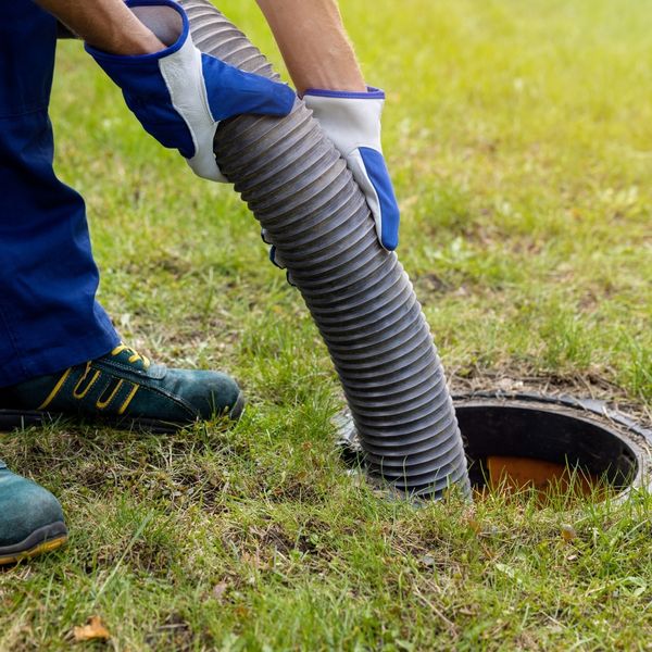 worker pumping a septic tank
