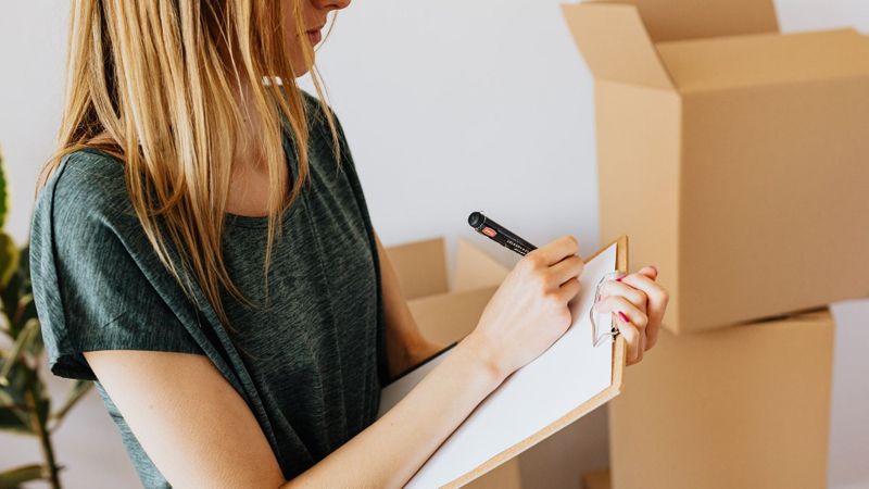 woman with checklist, moving boxes