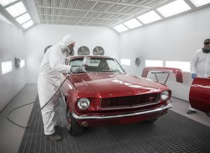 Man Painting a Vintage Red Mustang in a Spray Booth