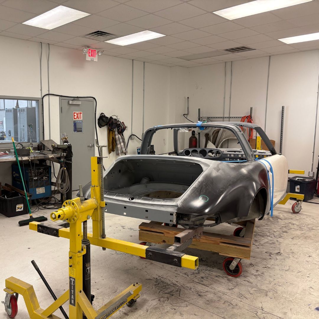 A vintage car shell sits on a professional restoration rotisserie as we prepare the chassis for a comprehensive rebuild.