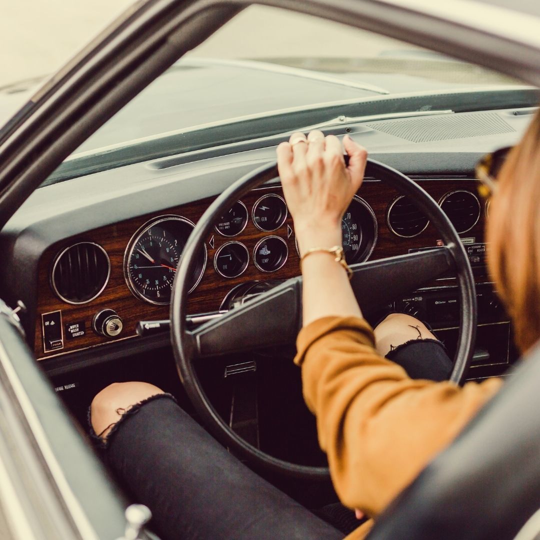 woman driving a classic car