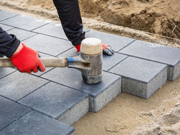  An image of someone installing concrete paver blocks
