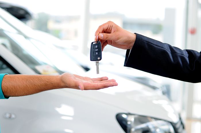 keys being put in hand in front of car