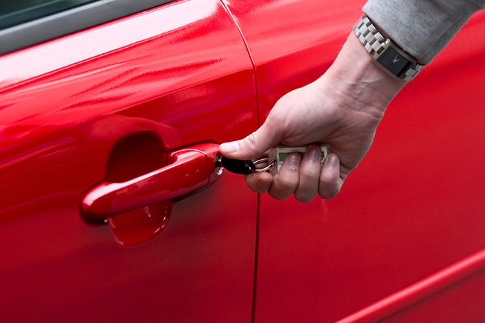 A man unlocking a new car door