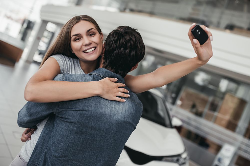 happy woman hugging while holding car keys