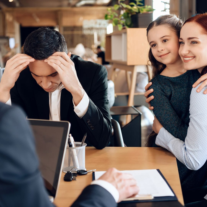 A divorcing set of parents meeting with a lawyer