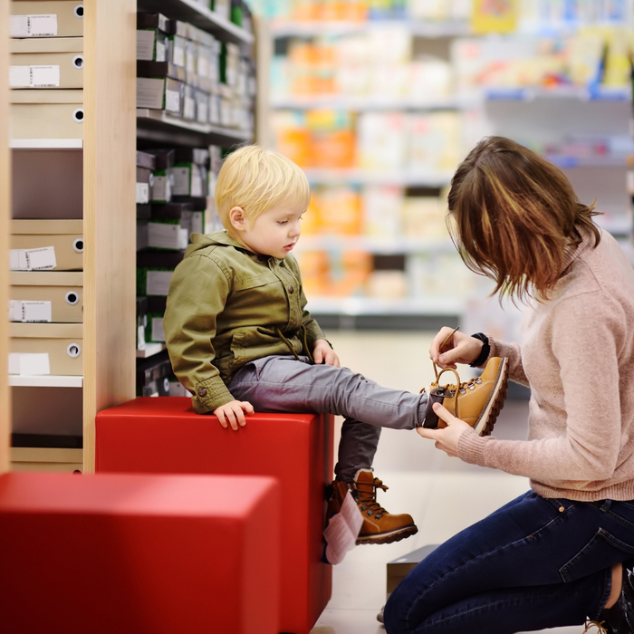 Mother helping a child try on shoes