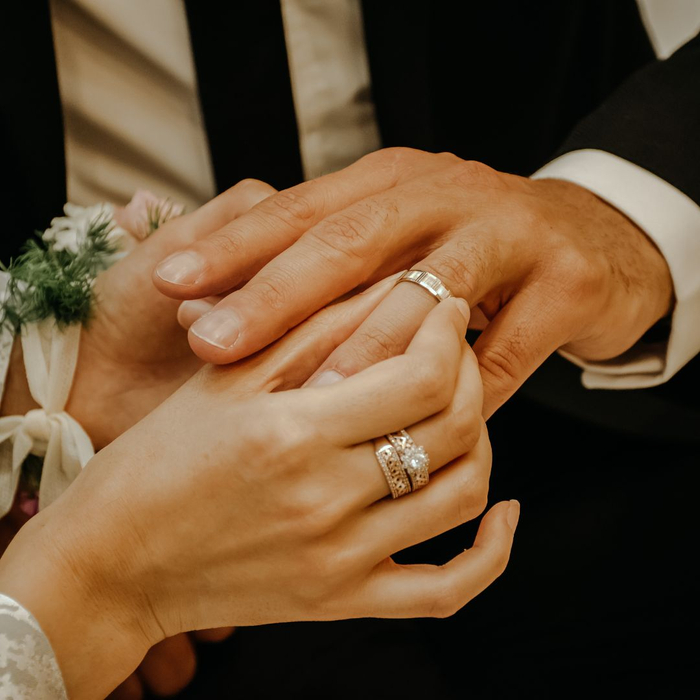 wife putting wedding band on husband's hand