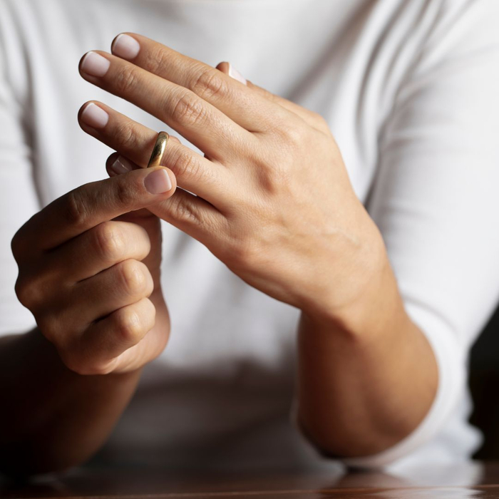 A woman takes her wedding band off