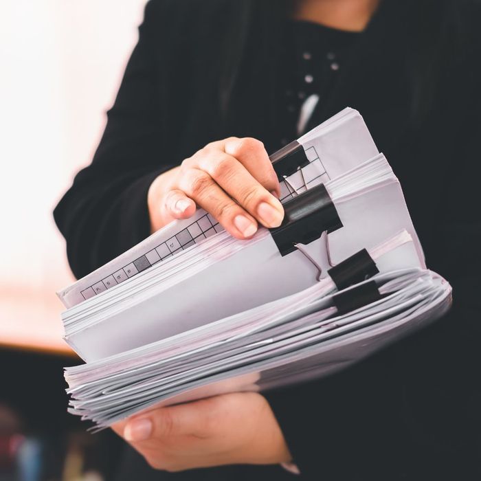 woman holding stack of documents woman holding stack of documents