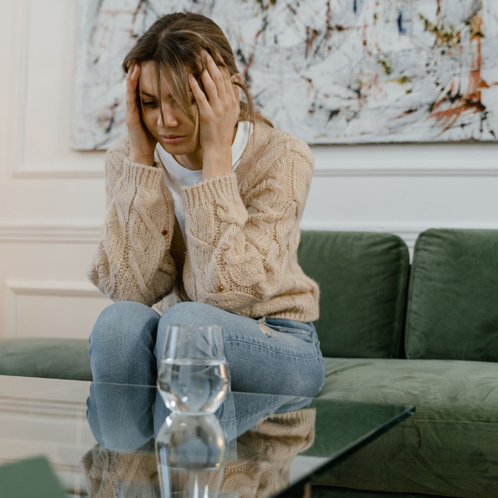 distraught woman sitting on couch distraught woman sitting on couch