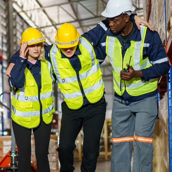 Co-workers helping a construction worker limp away from project