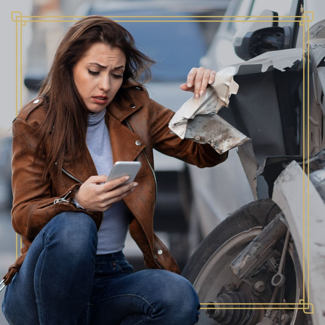 Person dialing on a smartphone at the scene of a car accident