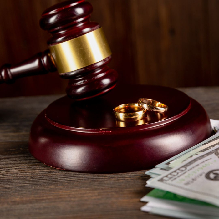 A gavel with wedding bands on it