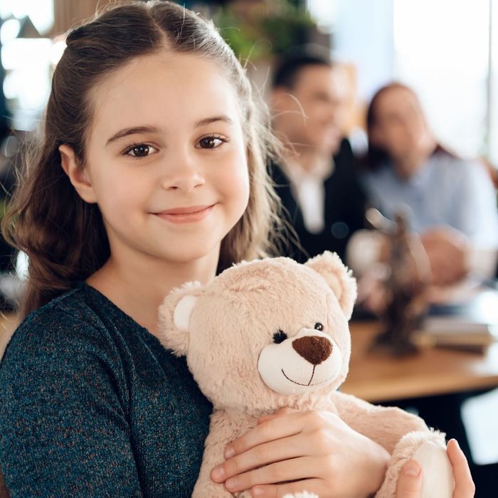 Child holds a teddy bear in a lawyers office