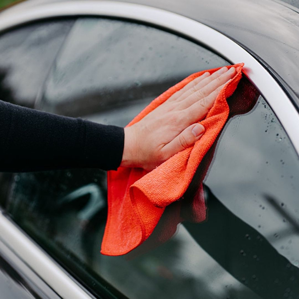 Someone cleaning a tinted window.