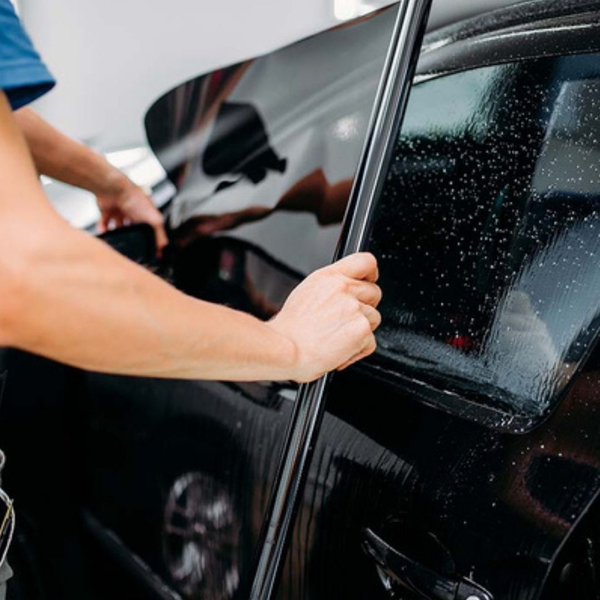 A tech applying window tint to a car.