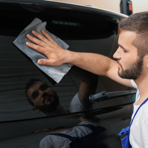 man applying car window tint