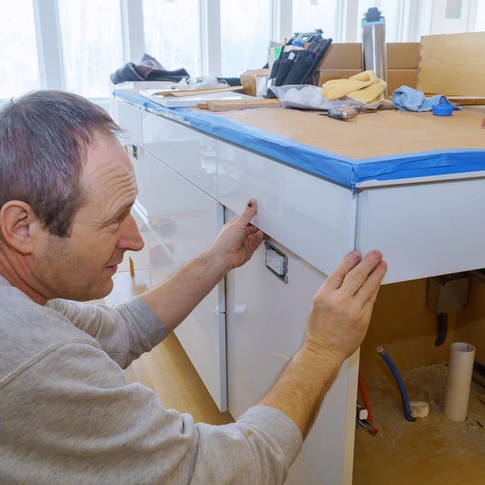 Man measures cabinets for a remodeling project