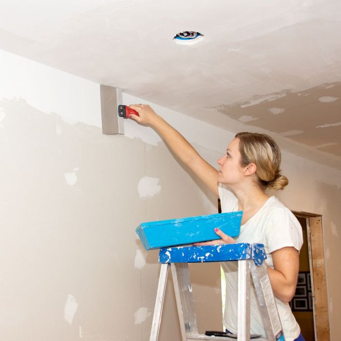 woman applies spackling on a wall