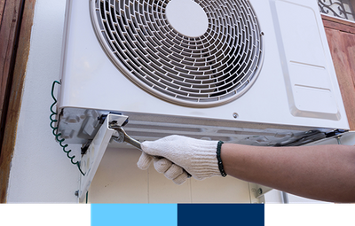 Close-up shot of an electrician with a wrench repairing an air conditioner.