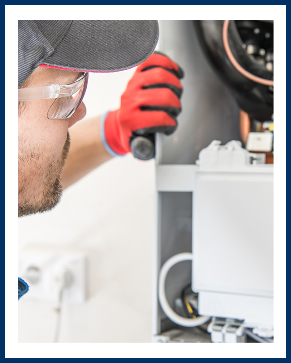 repairman looking into back of furnace