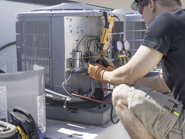 HVAC technician working on air conditioning unit