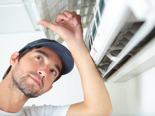 HVAC technicians installing a mini-split air conditioner 