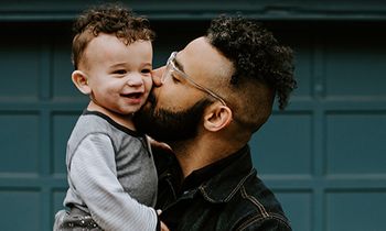 man kissing his son on the cheek