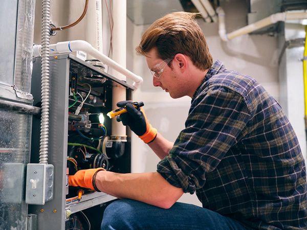 HVAC technician inspecting unit