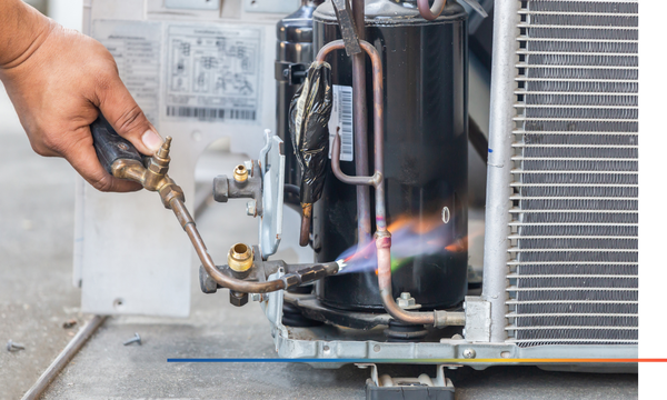 close up of air conditioning repair worker using a blow torch to weld