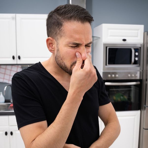 man plugging nose from drain odor