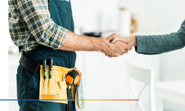 plumber and client shaking hands in kitchen