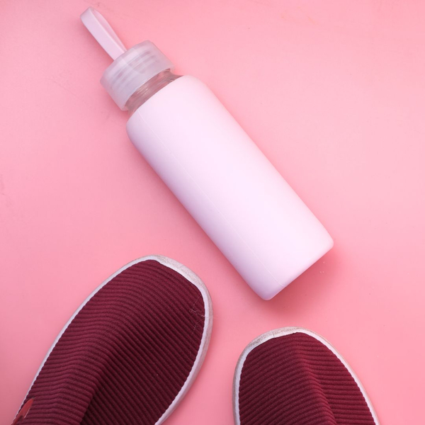 pink background with water bottle and shoes