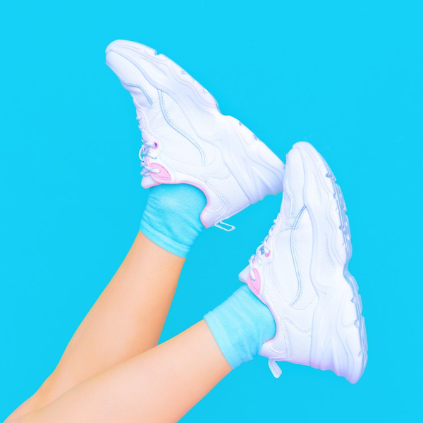 bright blue background with white sneakers