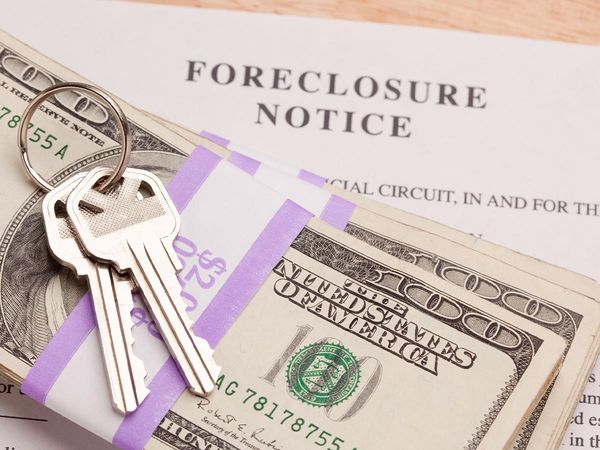 Money and keys on top of a foreclosure document.