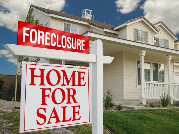  Foreclosure for sale sign in front of a home.