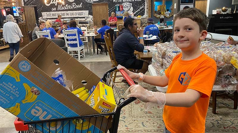 boy pushing cart for community outreach
