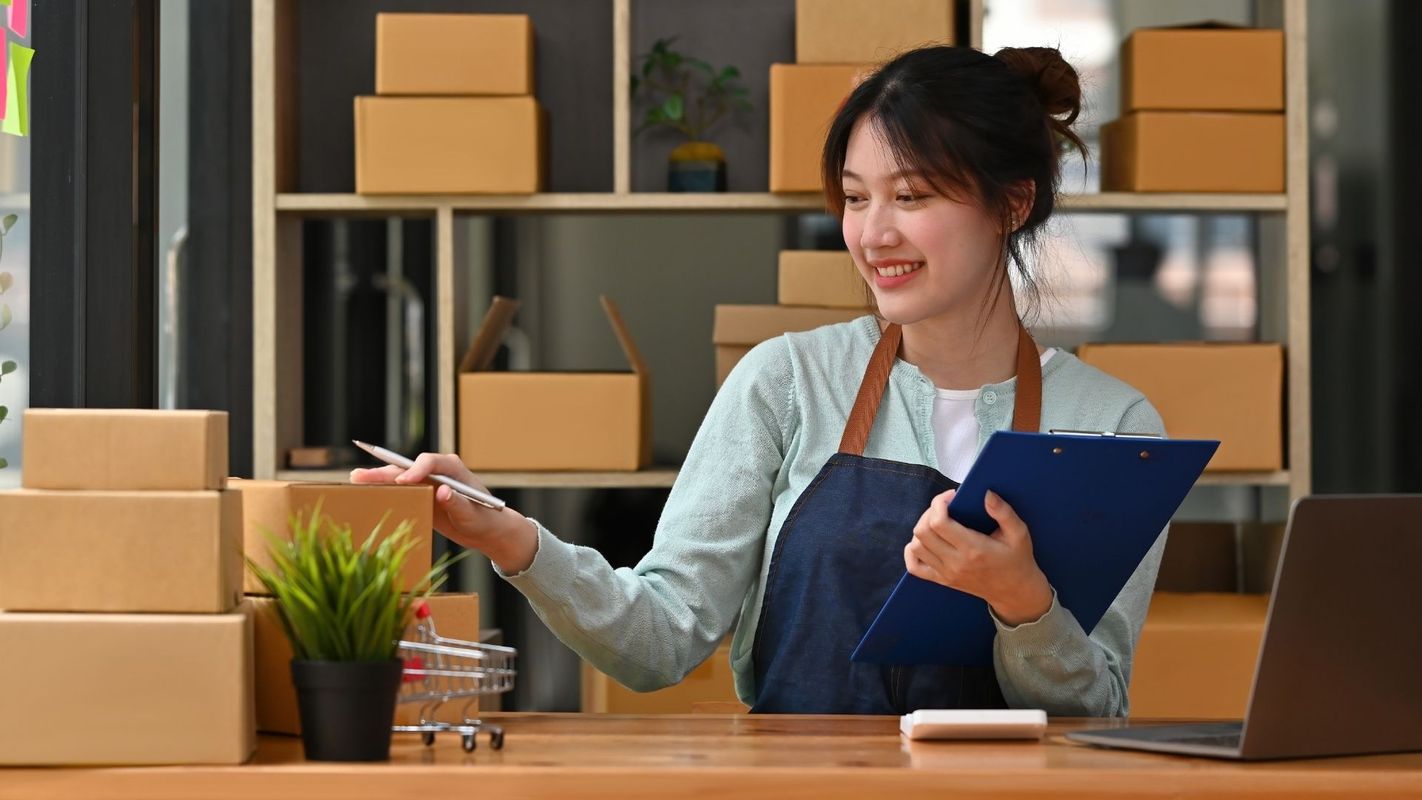 woman in overalls getting boxes ready for shipment