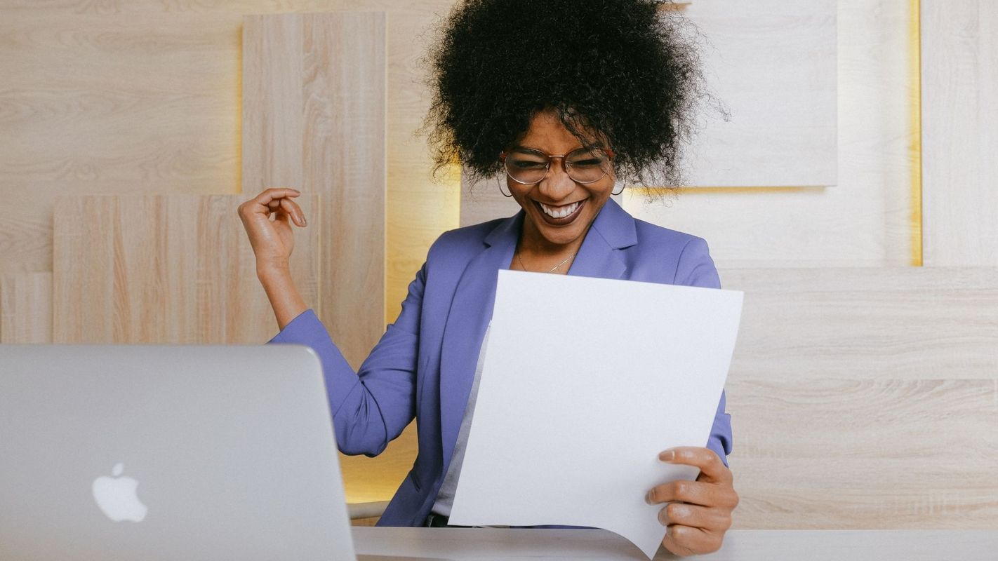 a happy woman looking at a document