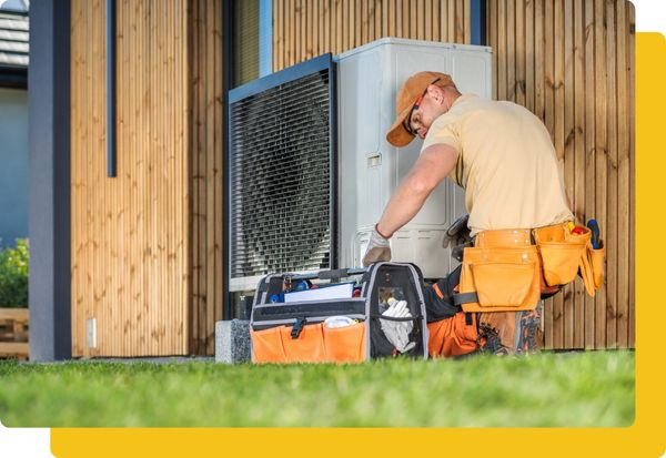 HVAC techinician working on a unit next to a fence