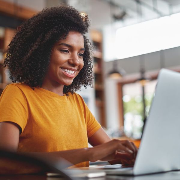 A smiling woman using a laptop