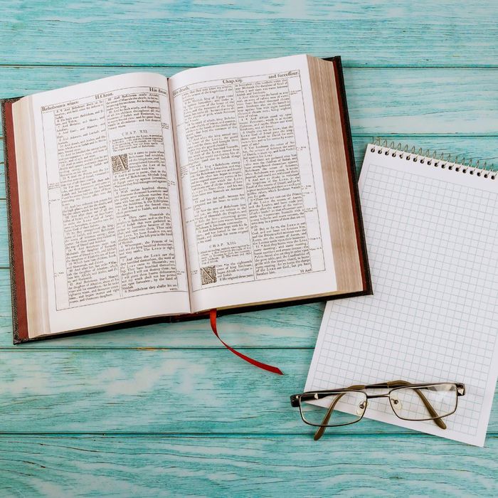 Bible next to a notepad and a pair of glasses. 