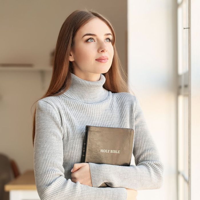 Woman clutching a Bible to her chest. 