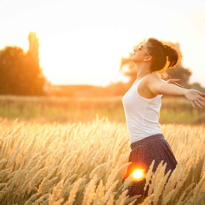 woman in field basking in the sunlight