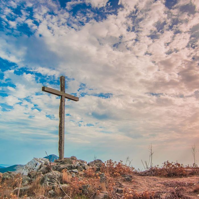 A wooden cross with blue sky in the background