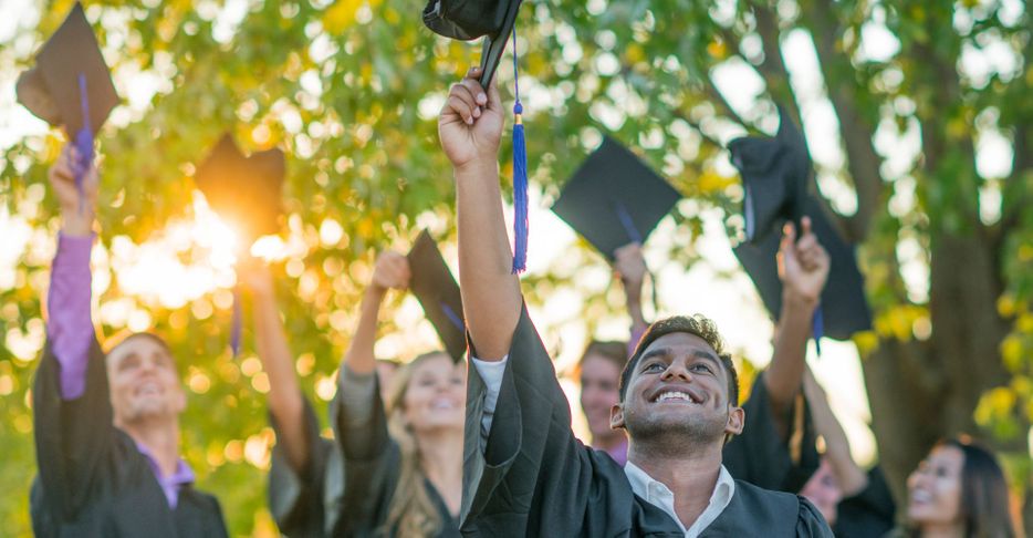 College graduates throwing their caps