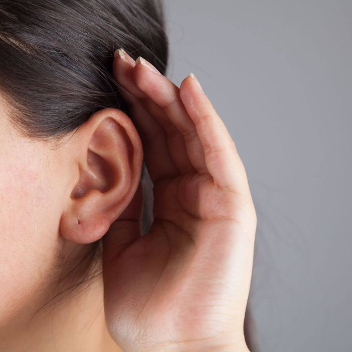 a girl cupping her ear to listen better
