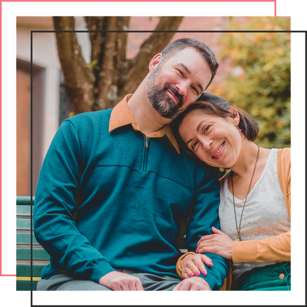 couple smiling sitting on a bench